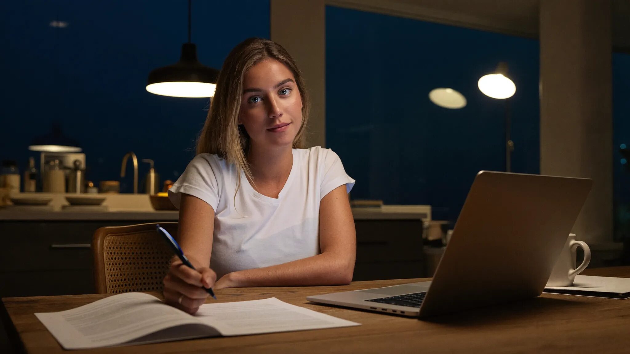 A buyer at her kitchen table reviewing the numbers on a car deal the night before visiting the dealership